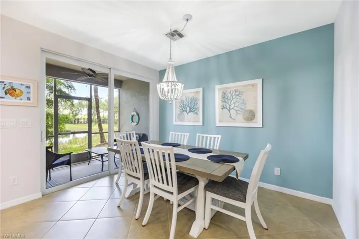 Tiled dining area with ceiling fan with notable chandelier