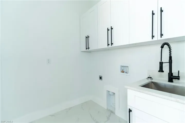 Laundry area featuring washer hookup, cabinets, sink, and hookup for an electric dryer
