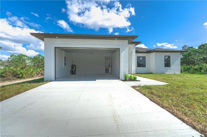 View of front facade with a garage and a front lawn