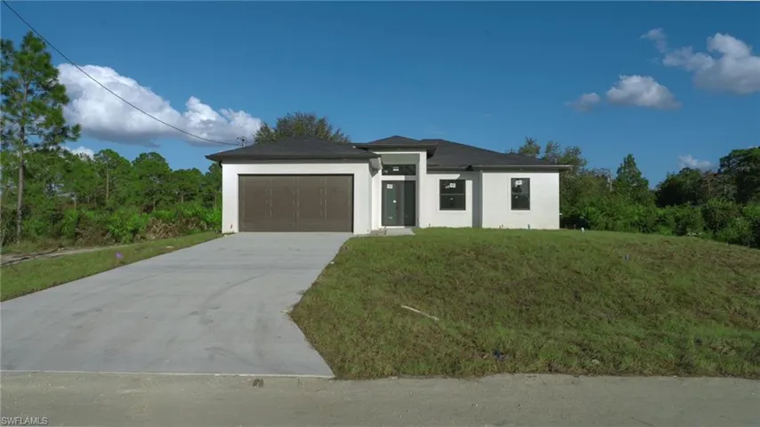View of front of home with a front lawn and a garage
