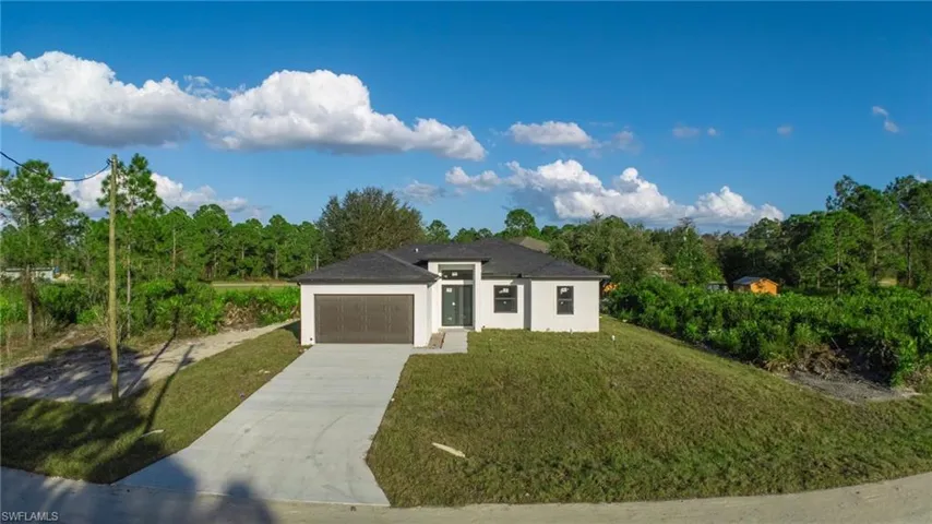 View of front of home featuring a front yard and a garage
