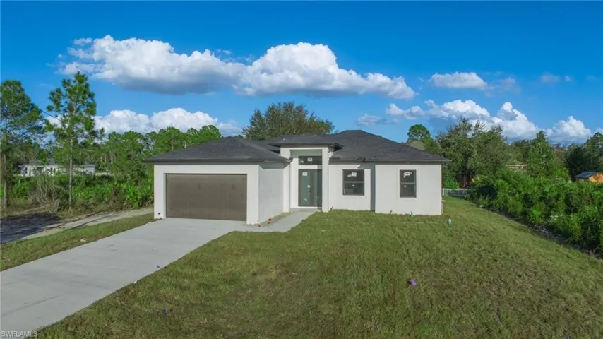 View of front of house with a front lawn and a garage