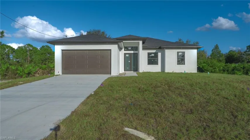 View of front of property with a front yard and a garage