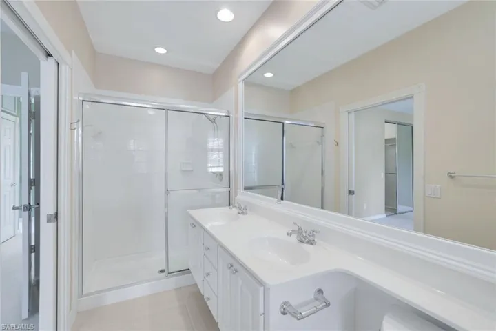Bathroom featuring vanity, tile patterned flooring, and a shower with door