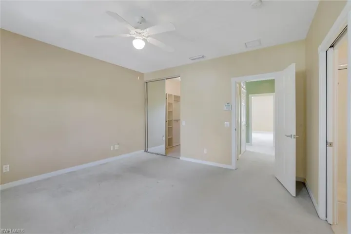 Unfurnished bedroom with ceiling fan, light colored carpet, and a closet