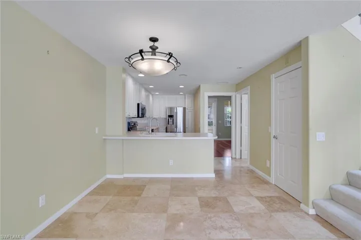 Kitchen featuring sink, white cabinetry, kitchen peninsula, decorative backsplash, and appliances with stainless steel finishes