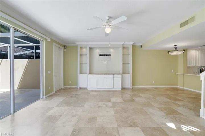 Unfurnished living room featuring ceiling fan, crown molding, and sink
