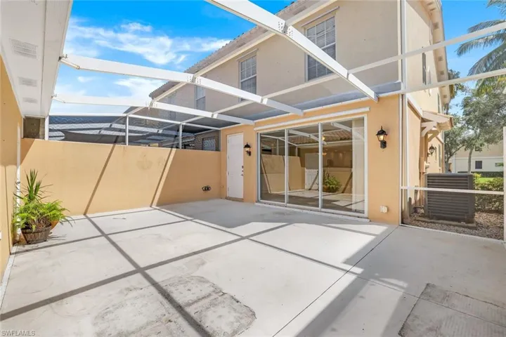 Back of property with a patio, central air condition unit, and glass enclosure