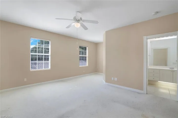 Carpeted empty room featuring ceiling fan