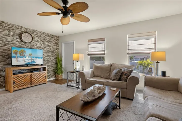 Carpeted living room with ceiling fan
