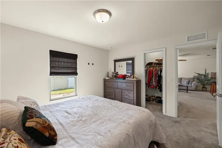 Carpeted bedroom with a spacious closet and a closet