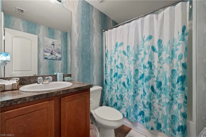 Full bathroom with vanity, toilet, and shower / bath combo with shower curtain
