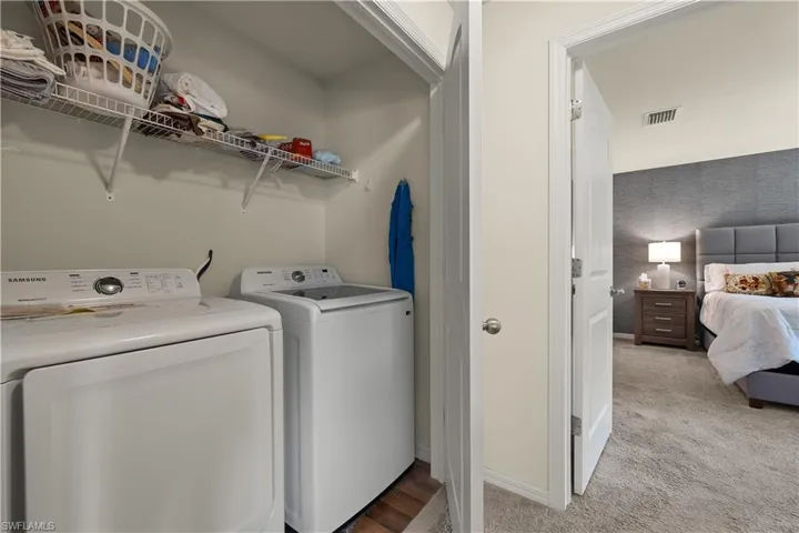 Laundry room featuring light carpet and washer and dryer