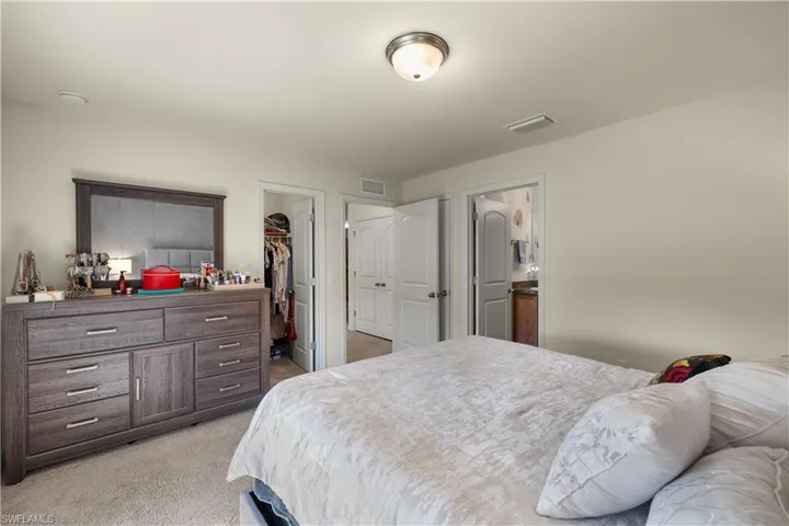 Bedroom featuring light carpet, a closet, and a walk in closet