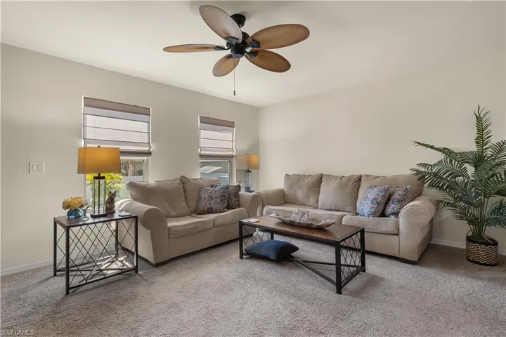 Living room featuring carpet flooring and ceiling fan