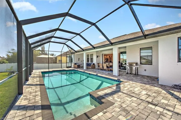 View of swimming pool with grilling area, a lanai, and a patio area