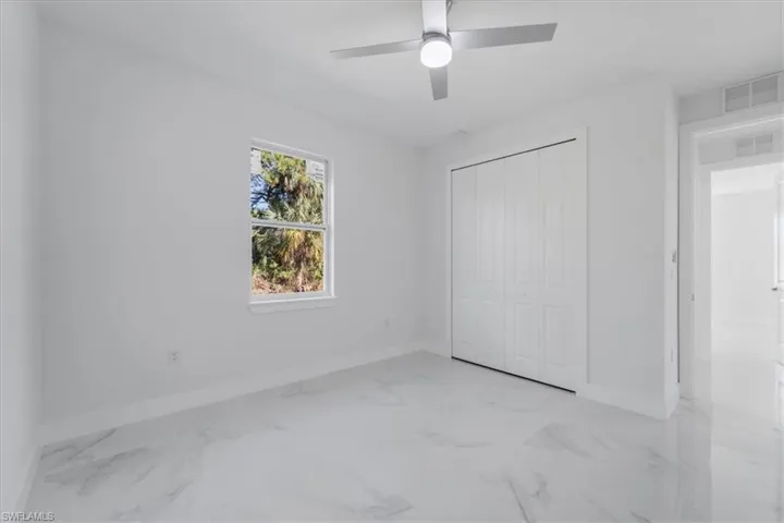 Unfurnished bedroom featuring ceiling fan and a closet