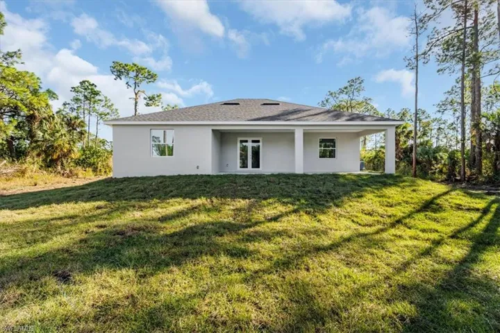 Back of house with a yard