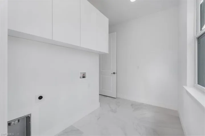 Clothes washing area with electric dryer hookup, cabinets, and hookup for a washing machine