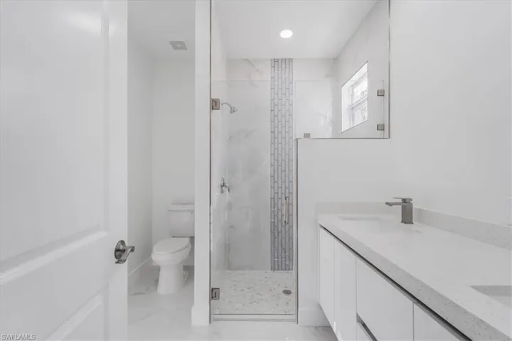 Bathroom with vanity, toilet, and walk in shower