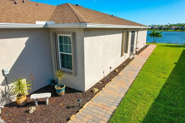 Walkway to entry door. Showcasing added pavers extending towards back of property