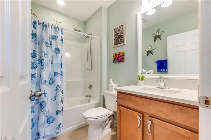 Full bathroom with vanity, shower / tub combo, toilet, and tile patterned floors