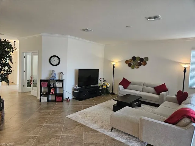 Tiled living room featuring crown molding