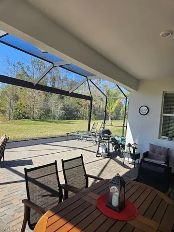 Wooden terrace with a yard, a lanai, and a patio