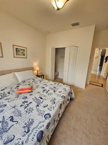 Carpeted bedroom with a closet