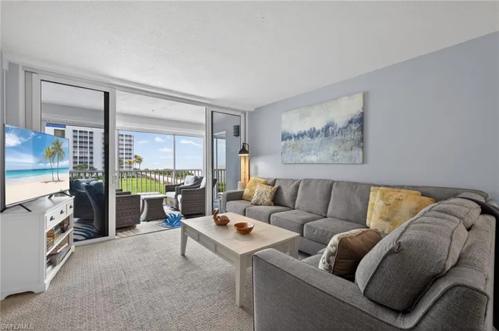 Living room with expansive views of the Gulf of Mexico (sliders open) - Virtually Edited Image