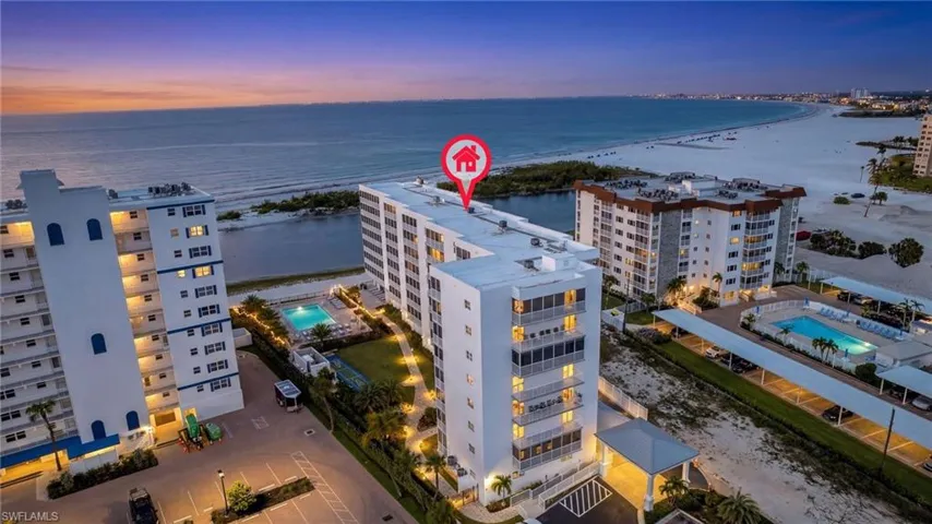 Aerial view at dusk with views of pool, beach and Gulf of Mexico.