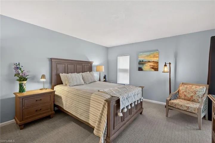 Bedroom featuring light colored carpeting and tranquil decor. - Virtually Edited Image