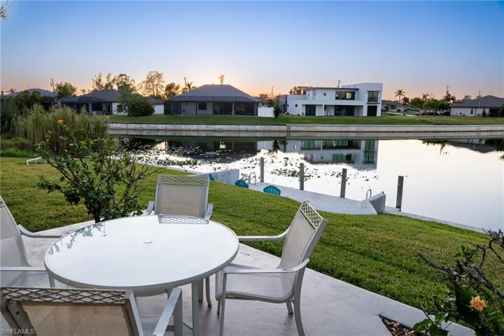 Patio terrace at dusk with a yard and a water view