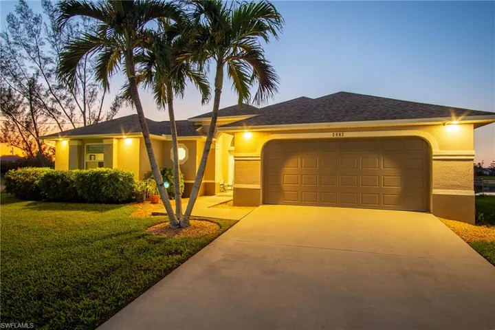 View of front of house with a garage and a yard
