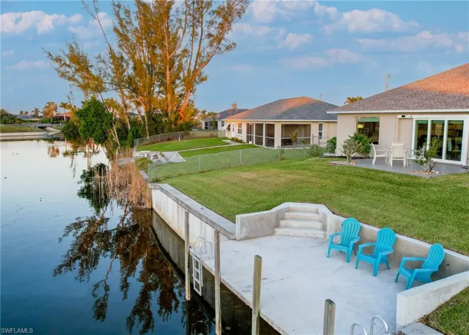 View of dock featuring a patio, a water view, and a lawn