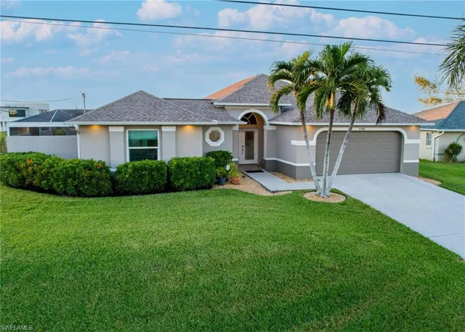 Single story home featuring a front yard and a garage