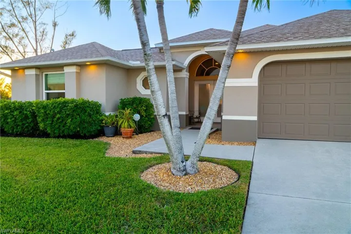 View of front of house featuring a garage and a front lawn