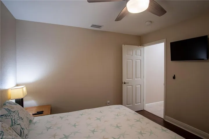Bedroom featuring ceiling fan and dark wood-type flooring