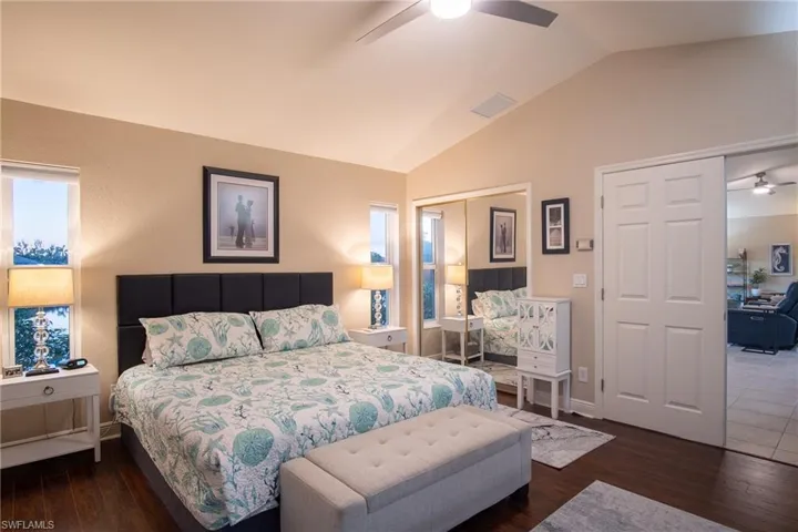 Bedroom with ceiling fan, dark hardwood / wood-style flooring, and lofted ceiling