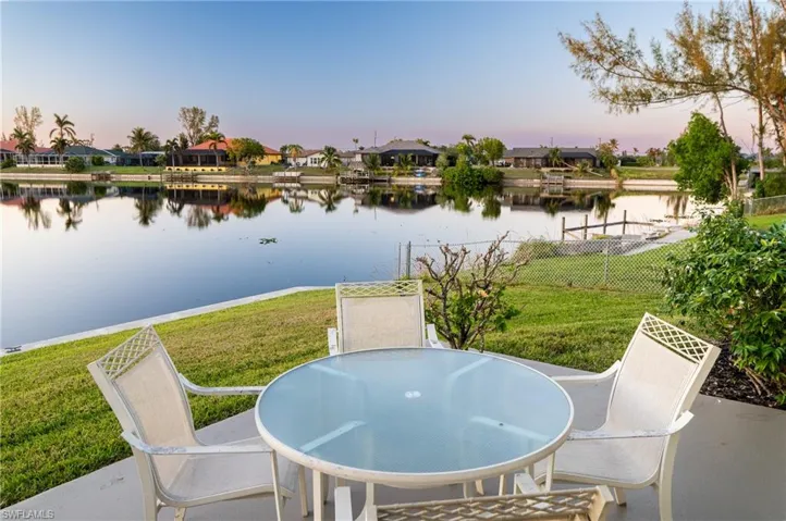 Patio terrace at dusk with a lawn and a water view