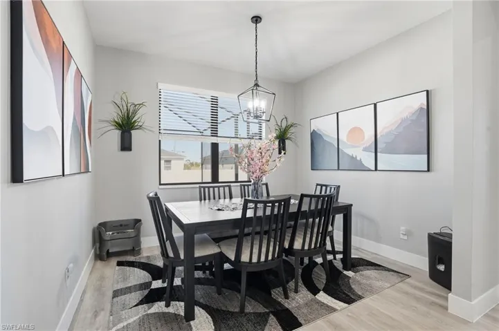 Dining room with light wood finished floors and suspended lighting
