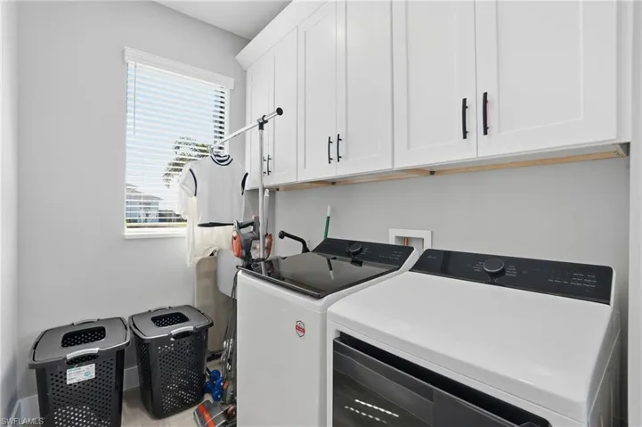 Laundry area featuring cabinet space and washer and clothes dryer