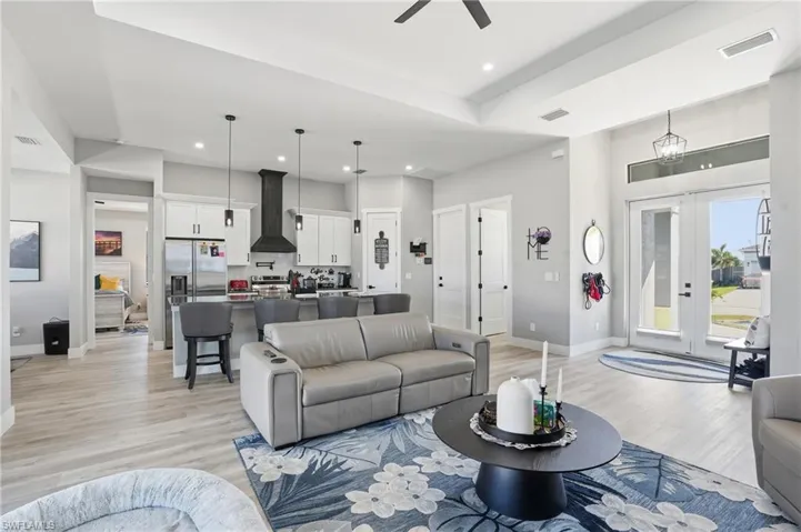 Living area featuring light wood-style flooring, french doors, ceiling fan, and recessed lighting