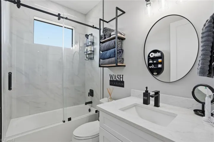 Bathroom featuring vanity and combined bath / shower with glass door