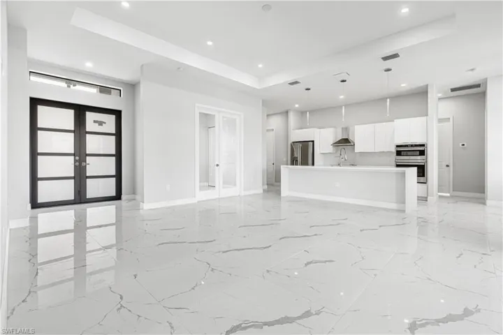 Open floorplan with a raised ceiling, gorgeous tile floors, kitchen, and much more