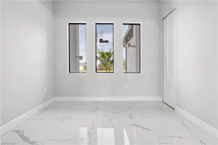 Room featuring french doors, a raised ceiling and beautiful tile floors