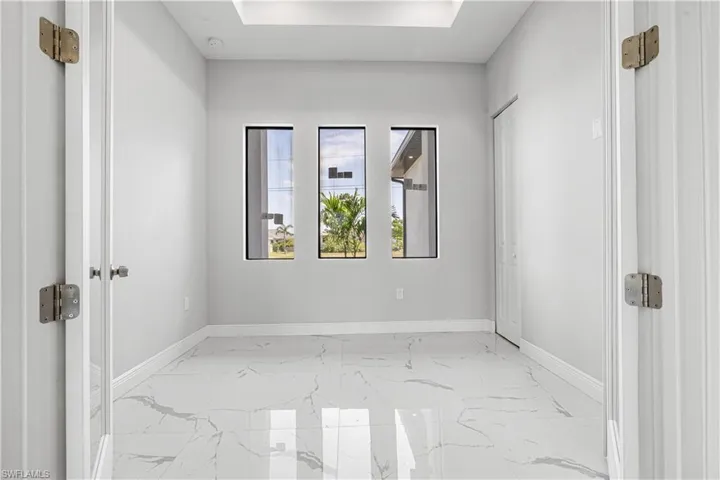 Room featuring french doors, a raised ceiling and beautiful tile floors