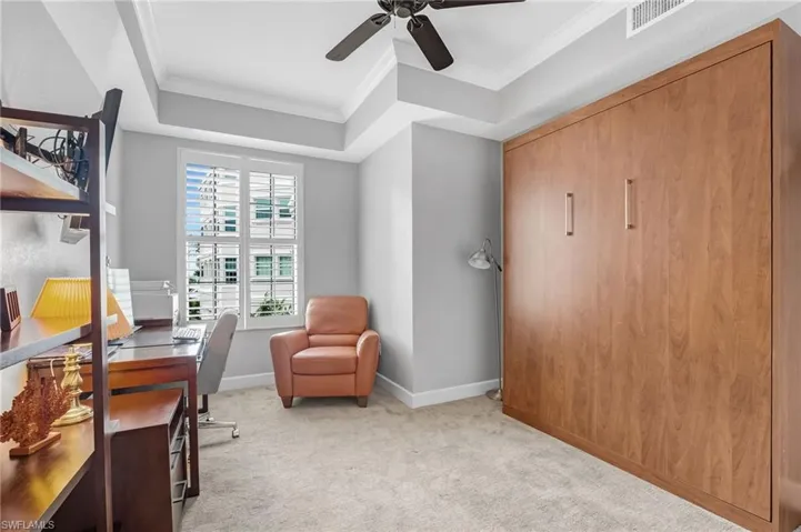 Currently serving as an office with a Murphy bed, the third bedroom boasts a tray ceiling and classic plantation shutters.