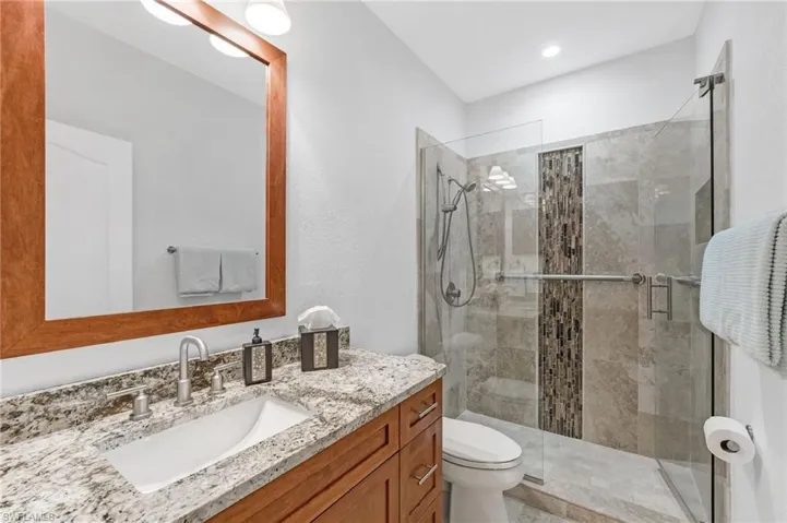 2nd full bathroom offers a walk in shower with seamless glass enclosure,  beautiful listello, granite single vanity countertop.