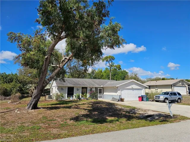 Single story home with a garage, concrete driveway, and a front yard